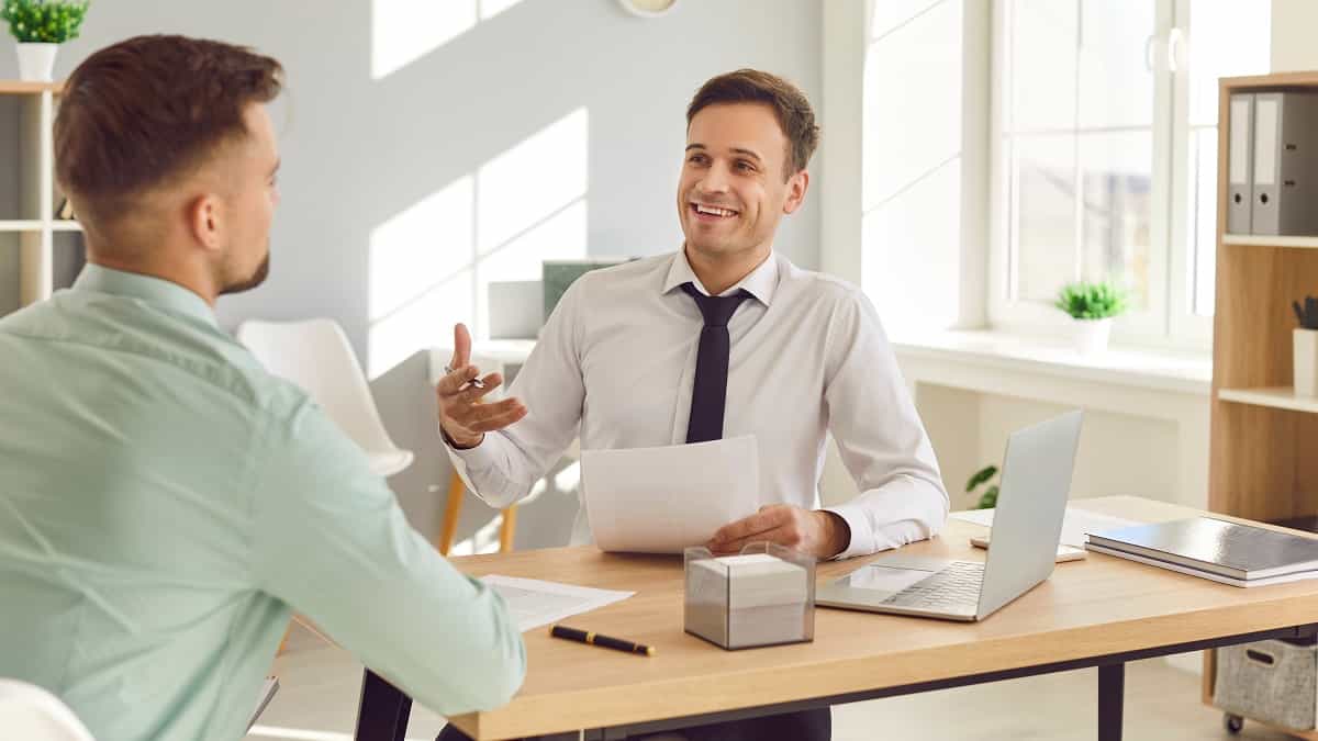 Image de Une de l'article sur le thème de l'entretien professionnel dans la fonction publique. Dans un bureau, 2 personnes sont assises autour d'une table et ont un échange.